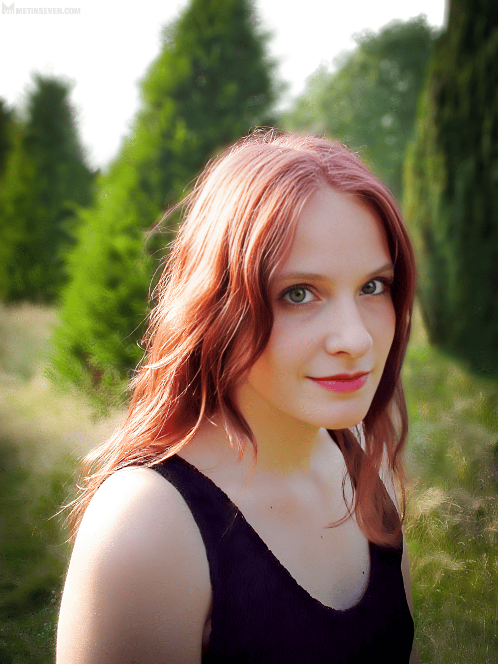 Color photograph of a young woman standing in a green nature environment.