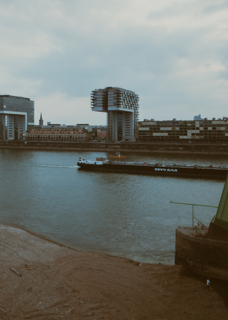 view of cologne´s 'kranhaeuser' architectural landmark with part of gas freighter navigating river rhine at pertty low water level