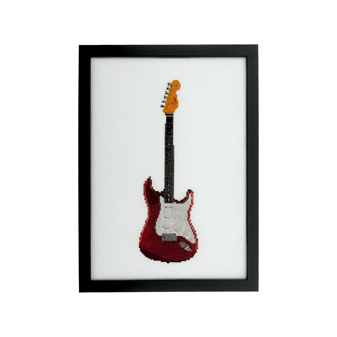red fender stratocaster guitar hand stitched in cross stitch in an impressionistic style on white aida fabric in a black frame