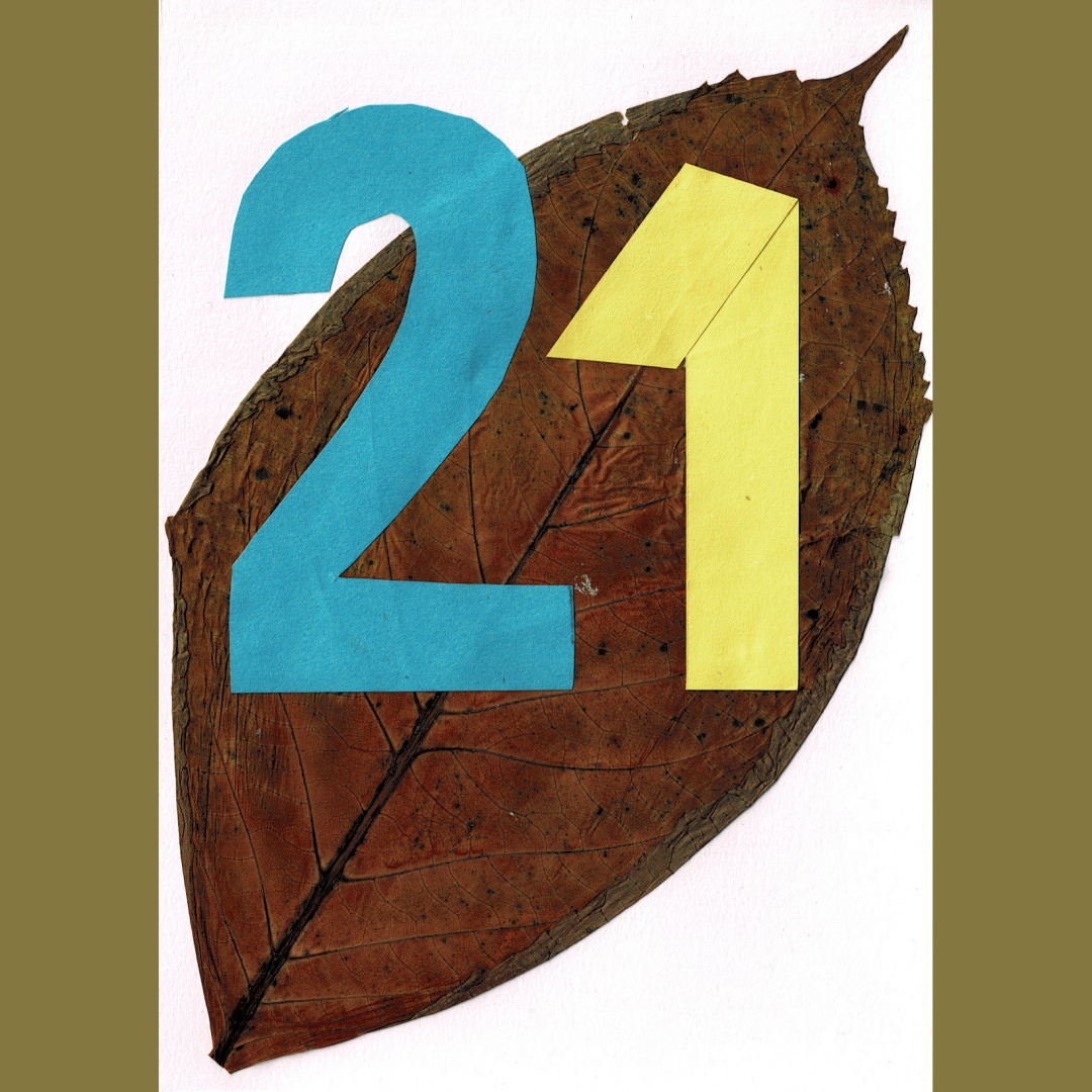 a collage of leaves and paper, depicting the number 21
