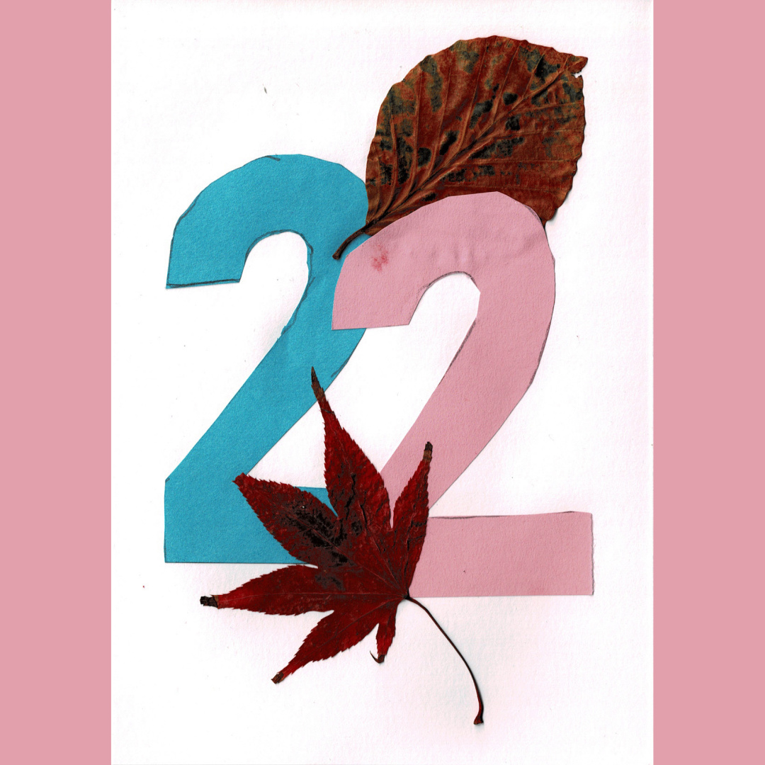 a collage of leaves and paper, depicting the number 22