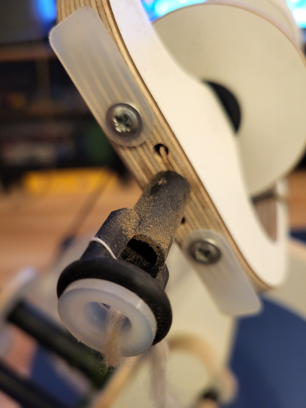 Close up of the spinning wheel's orifice which is full of brown dust.