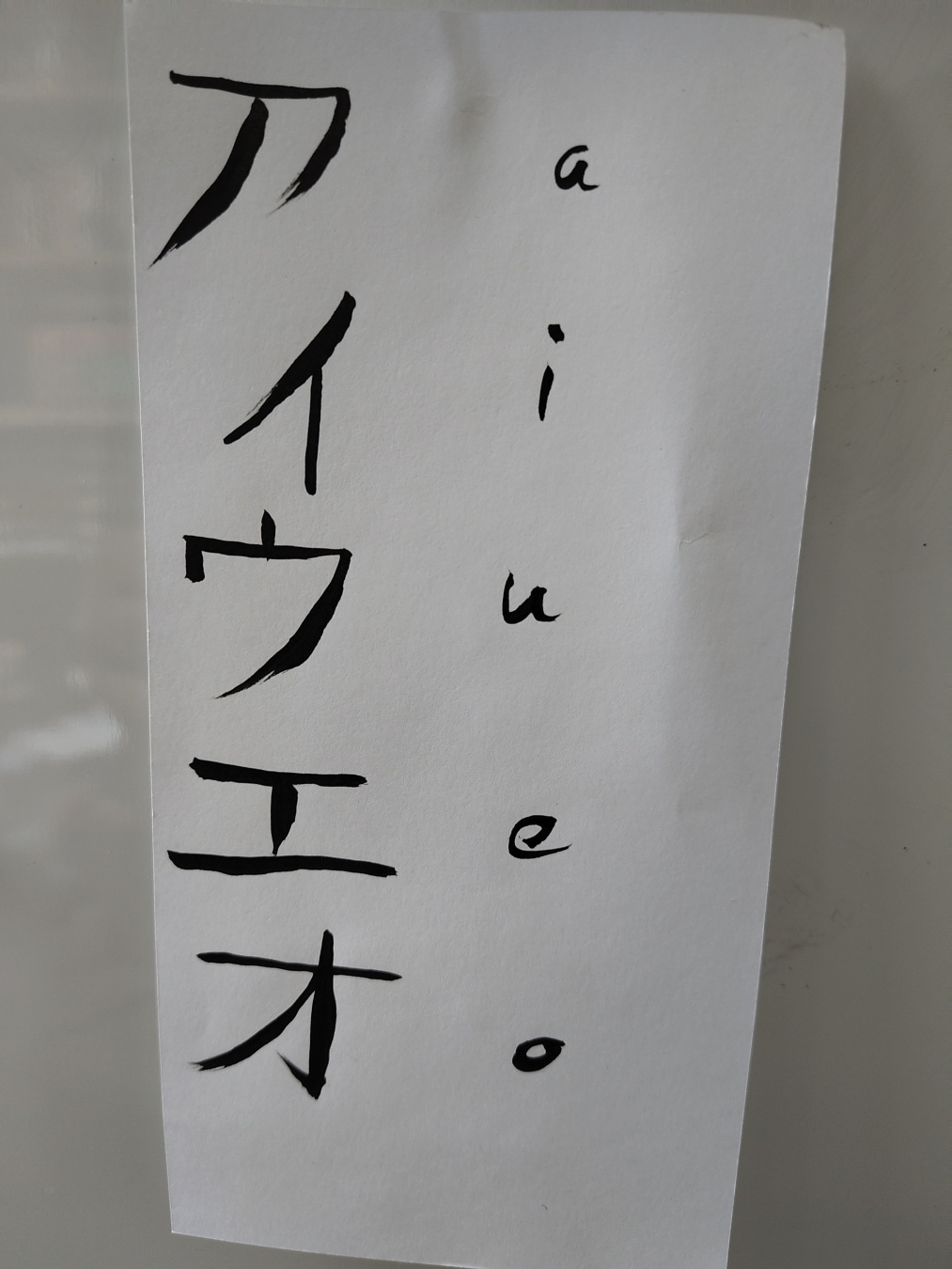 katakana a I u e o written with a brush and ink on paper